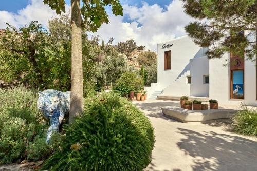 a building with a statue next to a palm tree at Nammos Hotel Mykonos in Psarou