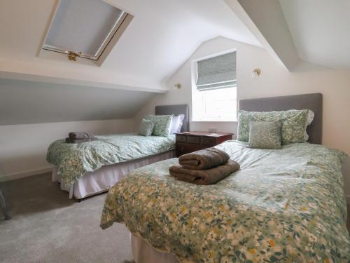 a bedroom with two beds and a window at Neptune Cottage in Conwy