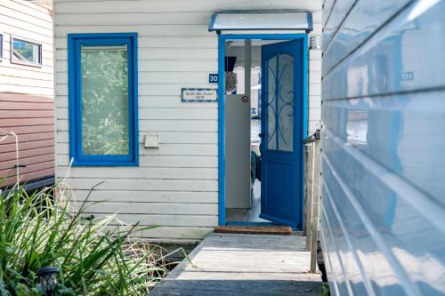 niebieskie frontowe drzwi białego domu w obiekcie The New Lake Boathouse w Amsterdamie