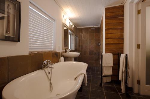 a bathroom with a tub and a sink at Silvermist Wine Estate in Cape Town