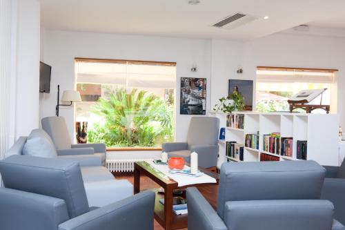 a living room with blue chairs and a table at Los Geranios in Port de Soller