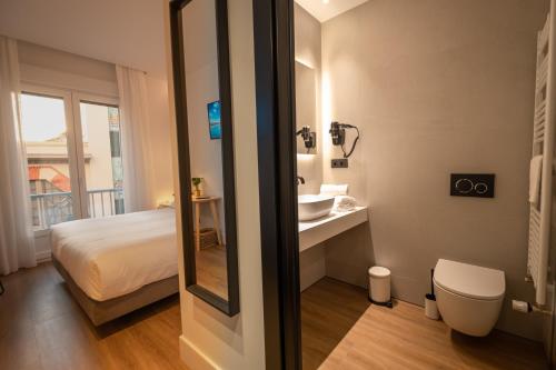 y baño con cama, lavabo y espejo. en PRINCIPE DE VERGARA ROOMS Lujo en el centro de Logroño en Logroño