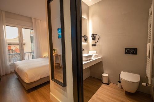 Un baño con una cama, un lavabo y un espejo. en PRINCIPE DE VERGARA ROOMS Lujo en el centro de Logroño, en Logroño