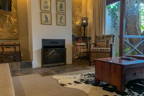 a living room with a table and a fireplace at Silvermist Wine Estate in Cape Town