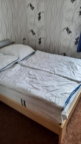 a bed with white sheets and pillows on it at Ferienhaus Baake in Mönkebude