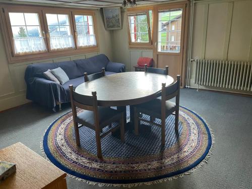 sala de estar con mesa, sillas y sofá en Via Alpsu 143, en Sedrun