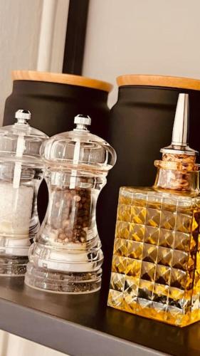 two glass vases sitting on a shelf next to a bottle at Ruim comfortabel appartement centrum Breda MET restaurant! in Breda