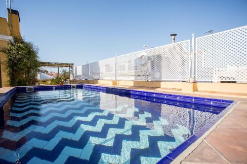 a swimming pool with blue and white tiles on a building at La Casa de María Castaña in Seville