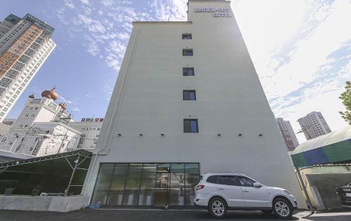 a white car parked in front of a building at Brown Dot Hotel Sinan in Gwangju