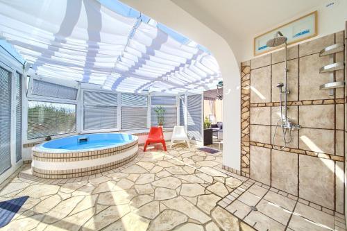 a bathroom with a large tub in a room at Holiday house NIKA with pool and jacuzzi in Linardići