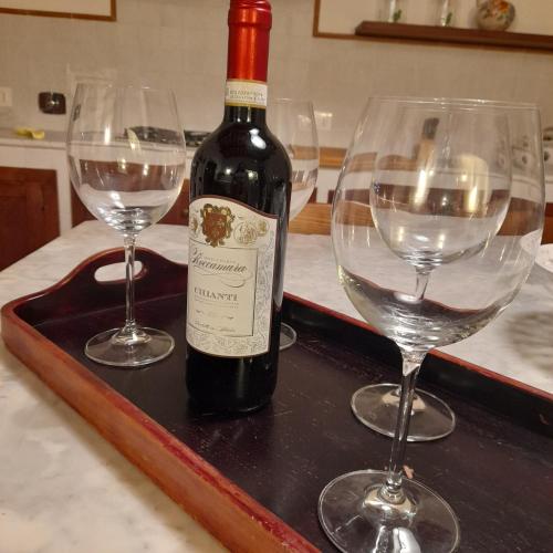 a bottle of wine and two wine glasses on a tray at La casa in piazza in Panicale