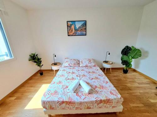 un lit dans une pièce avec deux plantes en pot dans l'établissement Casa Rosa : appartement moderne avec balcon, à Tassin-la-Demi-Lune