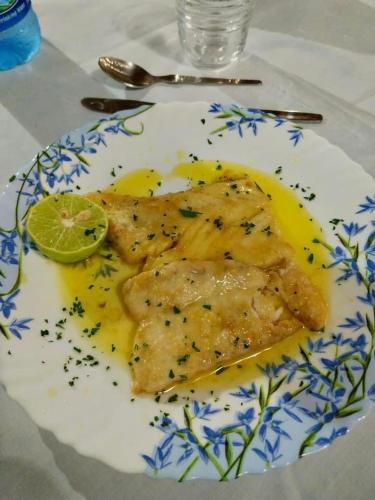a plate of fish with a slice of lime on it at BeB Sardegna2 Anjumasa village in Watamu