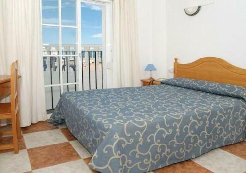 a bedroom with a bed and a large window at Hotel Betania in Benalmádena