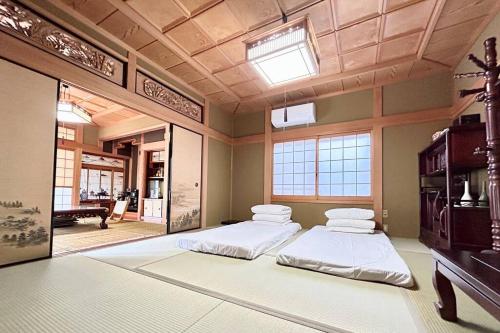 two beds in a large room with a ceiling at 640平米・海景房・独栋别墅・古民家“唯未亭” in Bōde