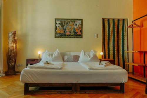 Schlafzimmer mit einem Bett mit weißer Bettwäsche und Kissen in der Unterkunft arte vida boutique guesthouse in Salzburg