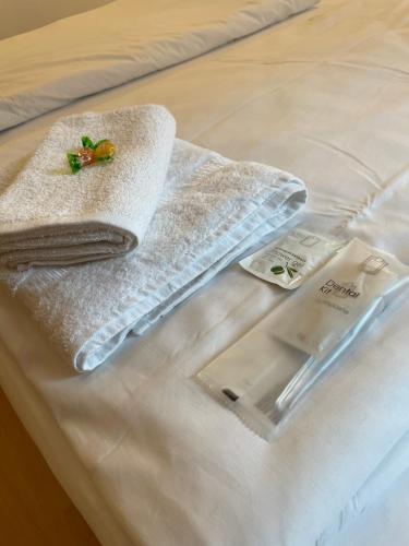 Una cama de hotel con una toalla y un termómetro. en Hotel Starlight, en Frankfurt