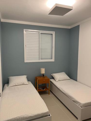 Dos camas individuales en una habitación con ventana. en Apartamento Ubatuba 405, en Ubatuba