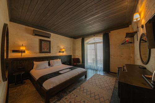 a bedroom with a bed and a desk in a room at Perla Cappadocia in Goreme