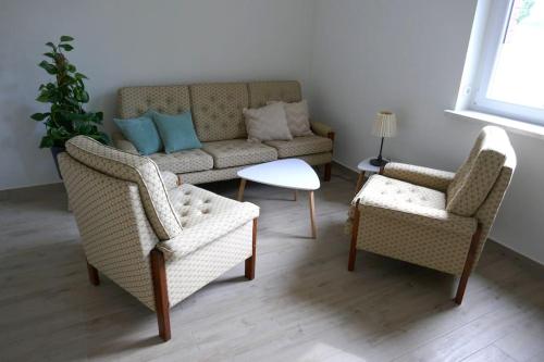 a living room with two chairs and a couch at Ferienwohnung Sieben Eulen in Garrey (Hoher Fläming) 