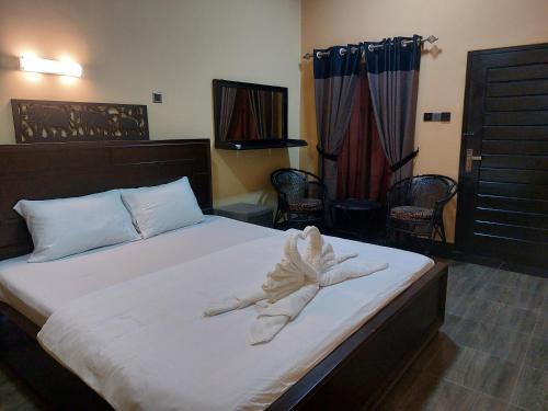 a bedroom with a large bed with white sheets at Edwin's Airport Garden in Negombo