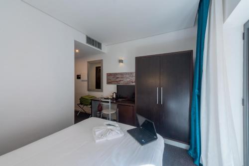 a bedroom with a bed and a cabinet with a book on it at Mercure Palermo Centro in Palermo