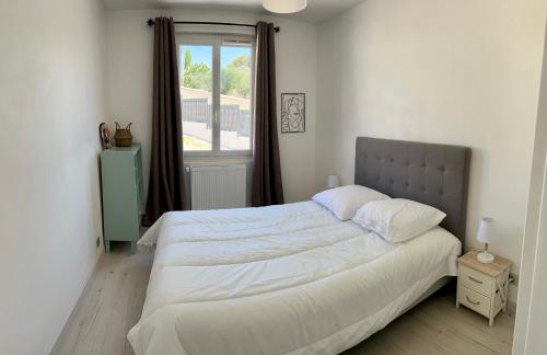 a bedroom with a large white bed with a window at Villa Familiale en Provence avec Piscine in Le Castellet