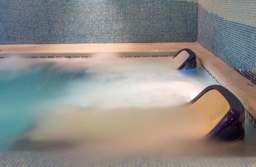 a bath tub filled with water in a bathroom at Leonardo Hotel Fuengirola Costa del Sol in Fuengirola