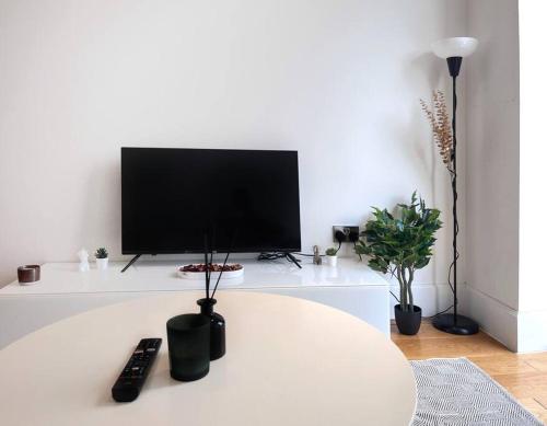 una sala de estar blanca con TV en una mesa blanca en Beautiful 2 Bed Apartment In Bow en Londres