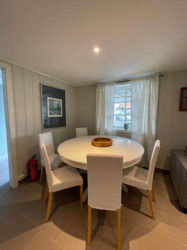 Larvik appartment in the city في لارفيك: غرفة طعام مع طاولة بيضاء وكراسي