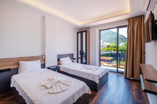 a hotel room with two beds and a balcony at Luxurylifevillas 5-6 in Fethiye