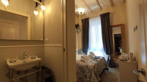 een badkamer met een wastafel en een bed in een kamer bij Residenza d'Epoca CAVALIERE in Bibbona
