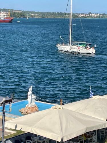 a sail boat in the water with a statue and a boat at ΜΕ ΘΕΑ ΤΗΝ ΓΟΡΓΟΝΑ in Preveza