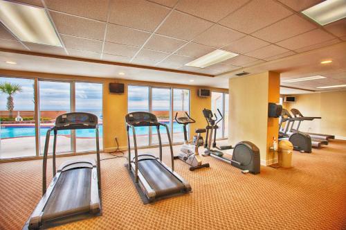 a fitness room with cardio equipment and a swimming pool at Sunrise Beach by Panhandle Getaways in Panama City Beach