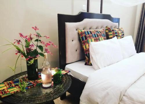 una camera con un letto e un tavolo con fiori di Kilimanjaro Pazuri Villas a Moshi