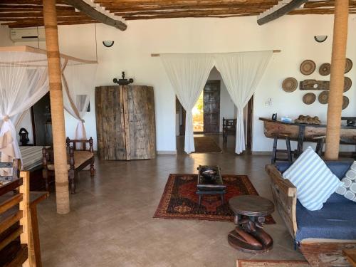 a living room with a couch and a table at Zi Villa Beach Cottage in Matemwe