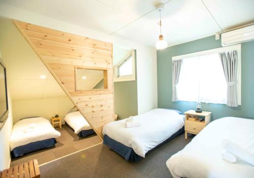 a room with two beds and a staircase in it at Chillps in Hakuba