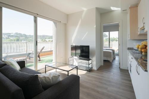 a living room with a couch and a tv at Someso Apartamentos Turisticos in A Coruña