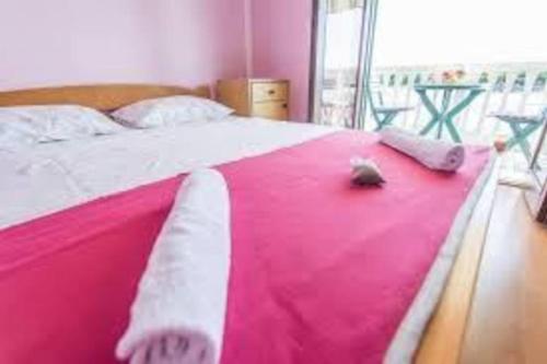 uma cama com um cobertor rosa e branco em Apartment Dragica (A2), Pašman em Pasman