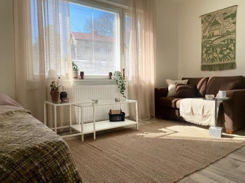 - une chambre avec un lit, un canapé et une fenêtre dans l'établissement Upea yksiö Kotkan Katariinassa, à Kotka
