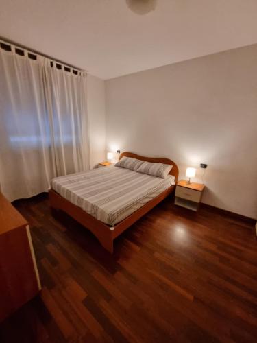 ein Schlafzimmer mit einem Bett und zwei Lampen an zwei Tischen in der Unterkunft Appartamento San Siro Stadio Fiera Milano City Life in Mailand
