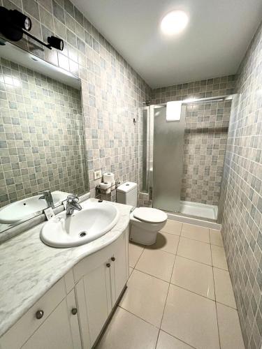 a white bathroom with a sink and a toilet at COSTA AZUL APARTMENTS - 2A in Puerto de Mogán