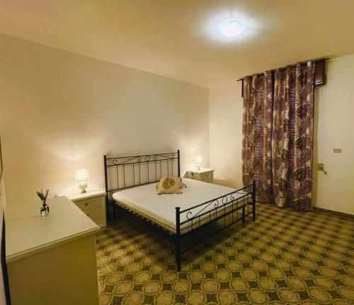 ein Schlafzimmer mit einem Bett, zwei Tischen und einem Fenster in der Unterkunft Dolce Casa in Casalabate