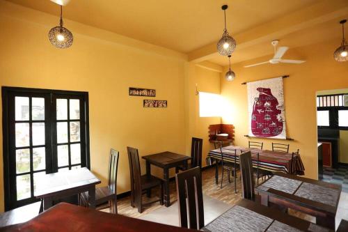 a restaurant with tables and chairs in a room at Edwin's Airport Garden in Negombo