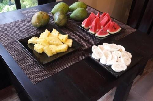 a table with three plates of fruit on it at Edwin's Airport Garden in Negombo