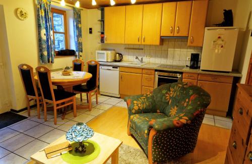 uma cozinha com uma mesa, um sofá e uma cadeira em Ferienwohnung Peuker em Neukirchen bei Sulzbach-Rosenberg