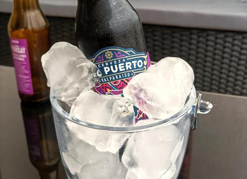 a bottle of beer in a bucket of ice at Depto. Full equipado in Iquique