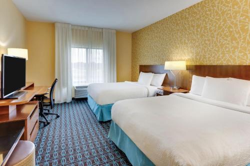 a hotel room with two beds and a flat screen tv at Fairfield Inn & Suites by Marriott Dunn I-95 in Dunn