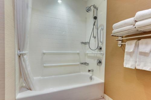 a bathroom with a tub and a shower with towels at Fairfield Inn & Suites by Marriott Dunn I-95 in Dunn