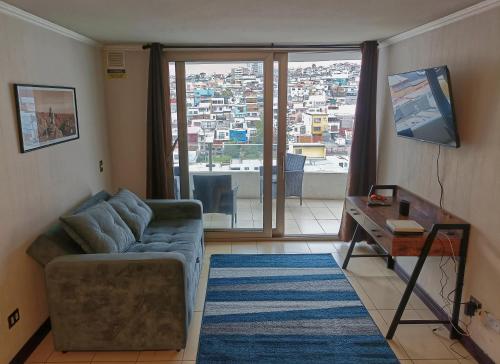 ein Wohnzimmer mit einem Sofa, einem Tisch und einem Fenster in der Unterkunft Depto. Full equipado in Iquique